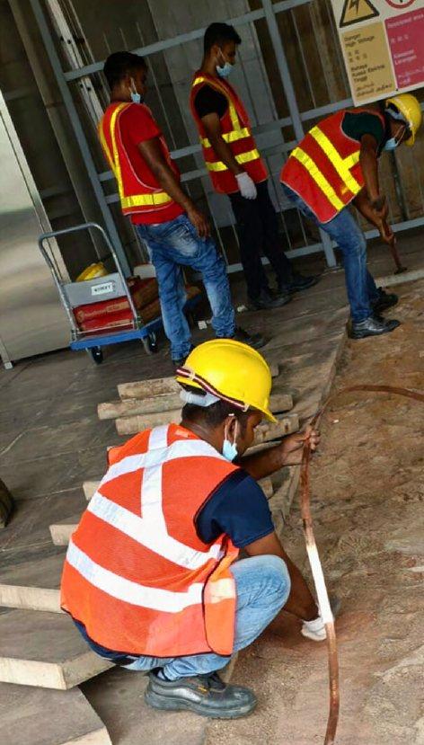 Seng Soon crew laying lightning protection conductor tape at an SMRT site